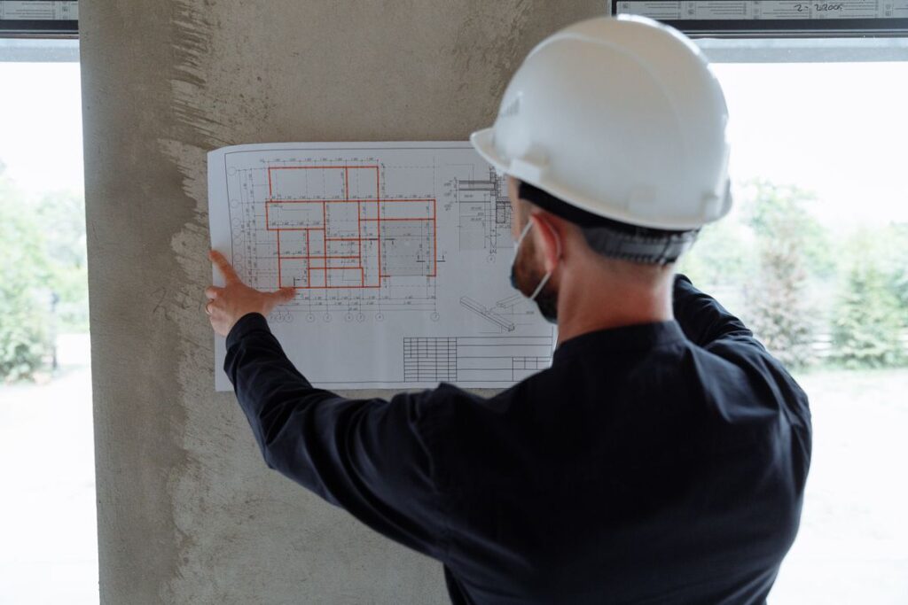 Kỹ sư đối chiếu bản vẽ mặt bằng tại công trình